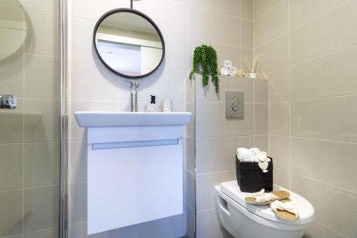 a bathroom with a sink and a mirror and a toilet at King David Apartment - J&J in Jerusalem