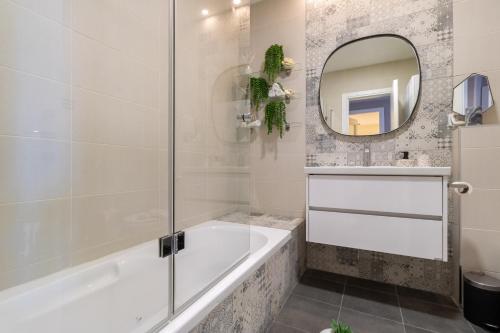 a bathroom with a tub and a mirror at King David Apartment - J&J in Jerusalem