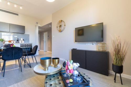 a living room with a tv on a wall at King David Apartment - J&J in Jerusalem