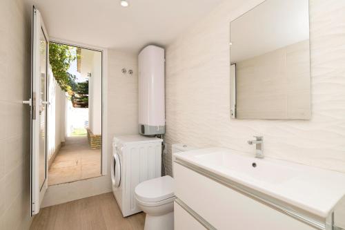 a bathroom with a toilet and a sink and a mirror at La Perla Costera in Chiclana de la Frontera
