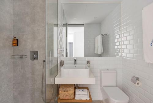 a white bathroom with a sink and a toilet at Candelaria10 in Cádiz