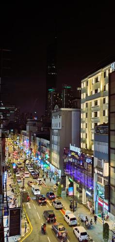 a busy city street at night with cars parked at Guesthouse@ Bukit Bintang in Kuala Lumpur