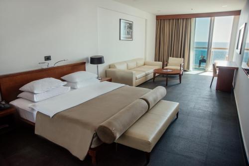 a hotel room with a large bed and a couch at Avala Resort & Villas in Budva