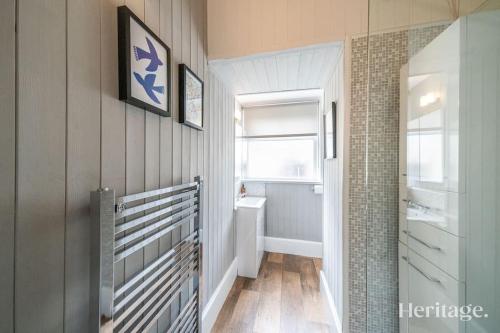 a bathroom with a hallway with a sink and a window at Barclay House, Stonehaven Seaside Home in Stonehaven