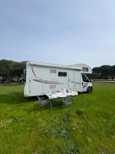 una caravana estacionada en un campo con una mesa y sillas en Camper Rent motorhome Albania, en Tirana