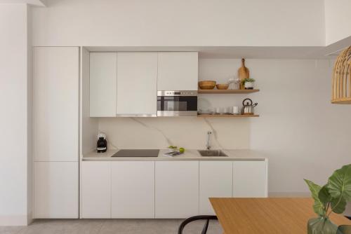 a white kitchen with a sink and a microwave at Candelaria10 in Cádiz
