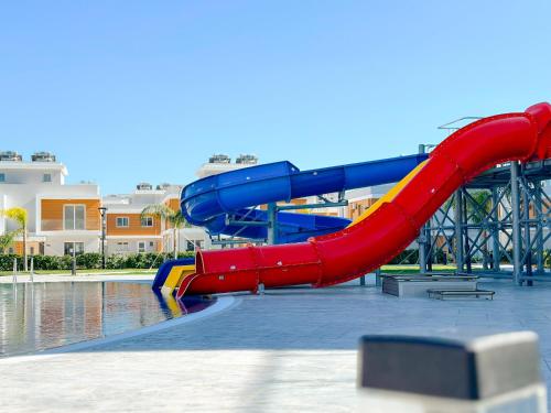 a red and blue slide in a water park at A 1 Bedroom in Royal Sun Elite, in Long Beach in İskele