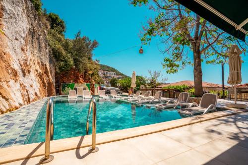 a swimming pool with lounge chairs and a mountain at Luna Kaş in Kas
