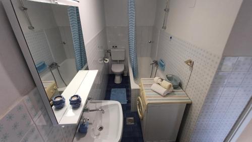 a bathroom with a sink and a toilet and a mirror at Casa Šimeti in Poreč