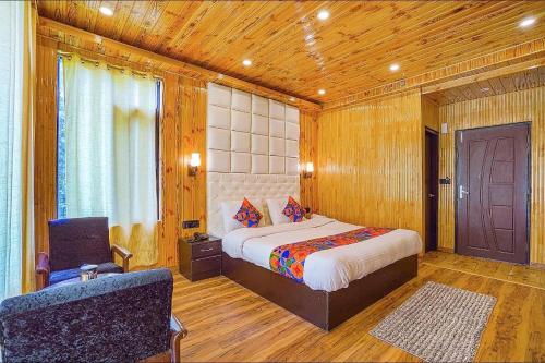 1 dormitorio con 1 cama y 1 silla en una habitación en Hotel Black Magic en Manāli