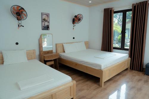a bedroom with two beds and a window at Tran Chau Garden Home in Cat Ba