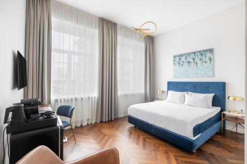 a hotel room with a bed and a chair at GRAND CROWN in Vilnius