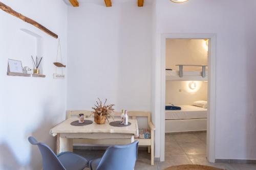 Zimmer mit einem Tisch, Stühlen und einem Etagenbett in der Unterkunft Eressian Lodgings, Skala Eressos Beach in Skala Eresou