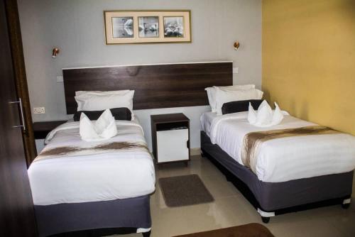 a hotel room with two beds and a fireplace at Etang Guesthouse in Nata