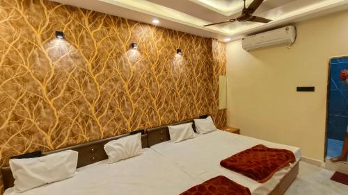 a bedroom with a bed in a room with a wall at Hotel Naagshree in Ujjain