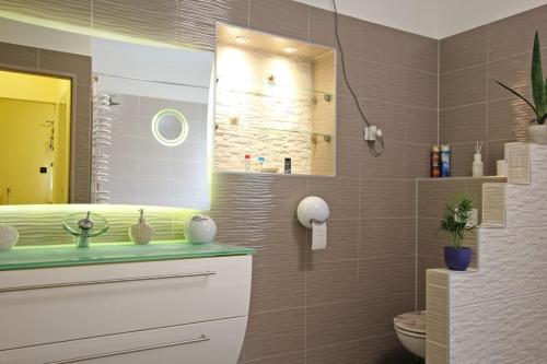 uma casa de banho com um lavatório, um WC e um espelho. em Outdoor Adventure Smart Riverside Pet Friendly em Budapeste
