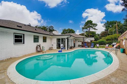 a swimming pool in front of a house at Poolside Bungalow with Fire Pit Fun and King Suite in Charlotte