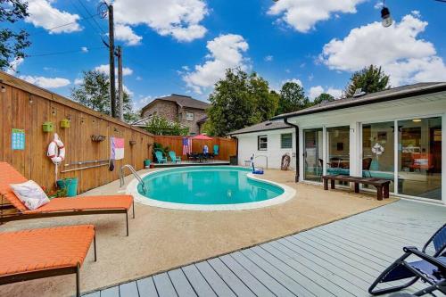 a backyard with a swimming pool and a wooden fence at Poolside Bungalow with Fire Pit Fun and King Suite in Charlotte