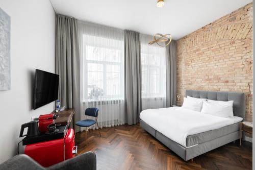 1 dormitorio con cama y pared de ladrillo en GRAND CROWN en Vilna