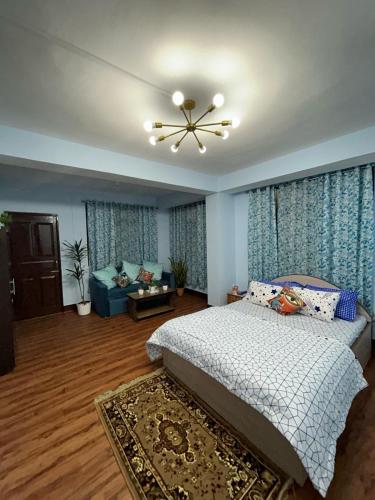 een slaapkamer met een bed en een plafondventilator bij Bluebird'snest in Gangtok