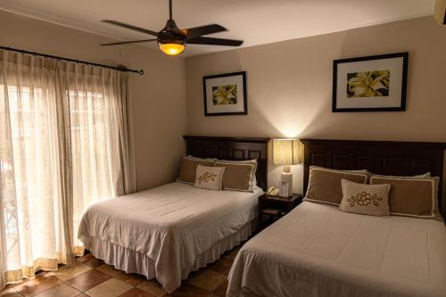 a bedroom with two beds and a ceiling fan at Hotel Cubitá Boutique Resort & Spa in Chitré