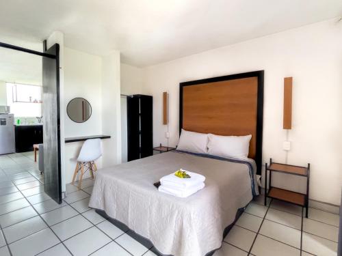 a bedroom with a bed with a wooden headboard at Departamentos H72 in Guadalajara