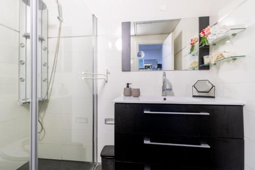 a bathroom with a black vanity and a mirror at King David Apartment - J&J in Jerusalem