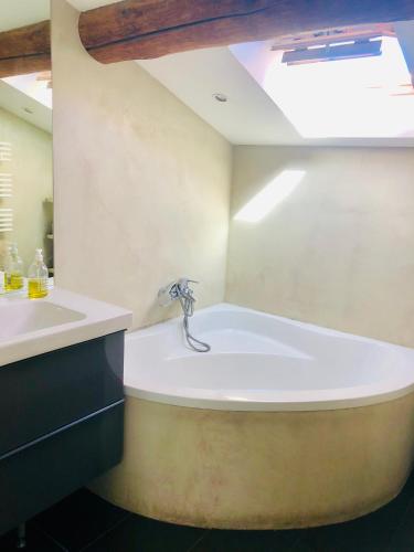 La salle de bains est pourvue d'une grande baignoire et d'un lavabo. dans l'établissement Joli duplex avec terrasse, à Marseille