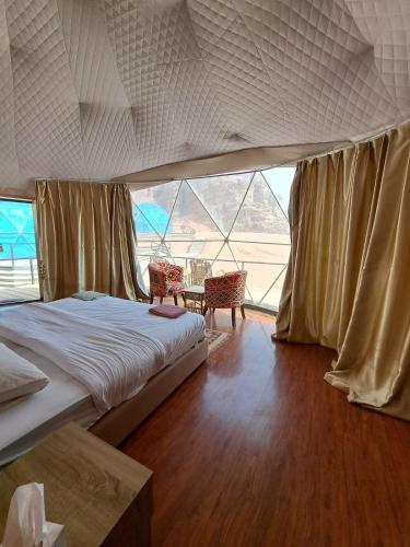 a bedroom with a bed and a table with chairs at Hasan Zawaideh Camp in Wadi Rum