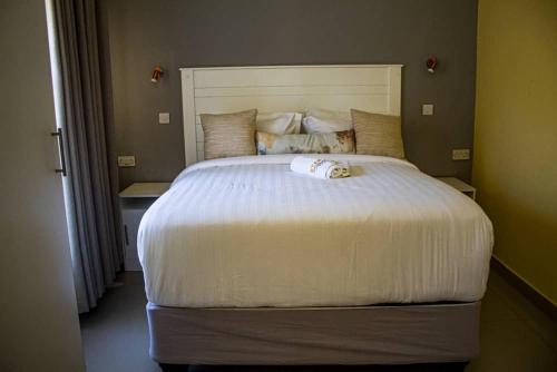 a bedroom with a large bed with a white comforter at Etang Guesthouse in Nata