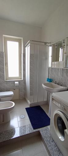 une salle de bain blanche avec une machine à laver à l'intérieur dans l'établissement Casa torelli azzurro, à Sellia Marina