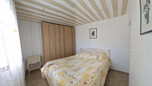 une chambre avec un lit et un plafond en bois dans l'établissement la Cigalière, à LʼIsle-sur-la-Sorgue