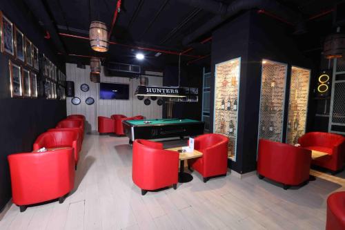 a restaurant with red chairs and a pool table at Fortis Hotel Fujairah in Fujairah