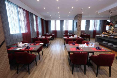 a restaurant with tables and chairs in a room at Fortis Hotel Fujairah in Fujairah