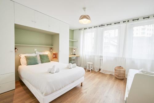 - une chambre blanche avec un grand lit blanc et un bureau dans l'établissement Florida emplacement parking, à Annecy