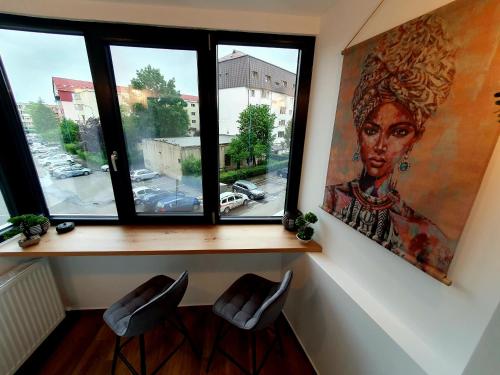 um quarto com uma janela com um retrato de uma mulher em Central Nest Apartment em Brasov