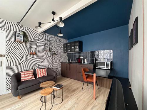 ein Wohnzimmer mit einem Sofa und einer Küche in der Unterkunft WANDERLUST - Studio confort à 100m plage Solidor in Saint-Malo