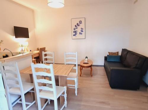 ein Wohnzimmer mit einem Tisch und einem Sofa in der Unterkunft Les alouettes in Nanterre