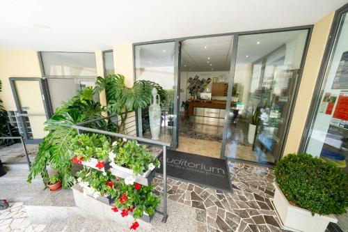 a lobby with plants in pots in a building at Hotel Auditorium in Bari