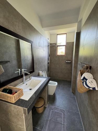 a bathroom with a sink and a toilet at Shades Hotel & Villa in Matara