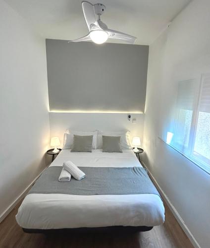 1 dormitorio blanco con 1 cama y ventilador de techo en Centric 3ºD, en Madrid