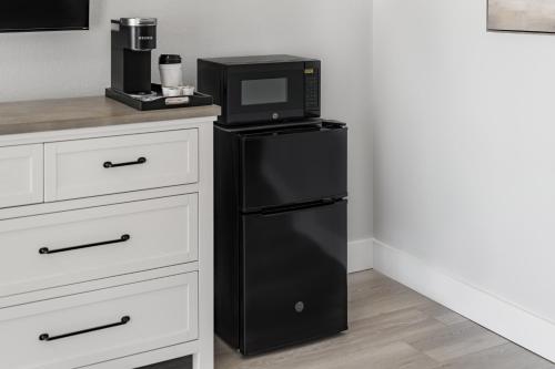 a black refrigerator with a microwave on top of it at Mia's Boutique Hotel in Nags Head