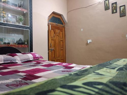 een slaapkamer met een bed en een houten deur bij Sangeeta's in Ayodhya
