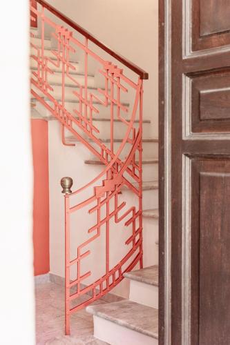 a set of stairs with a red railing next to a door at Sella&Mosca Casa Villamarina in Alghero