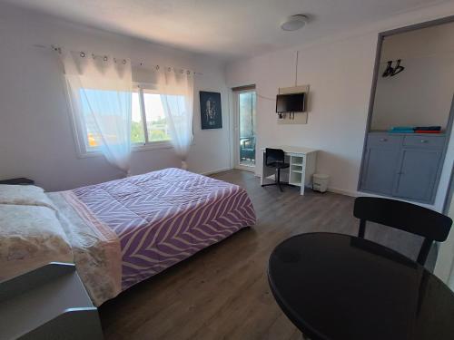 1 dormitorio con 1 cama, 1 mesa y 1 silla en Hostal Bélgica en Palmanova
