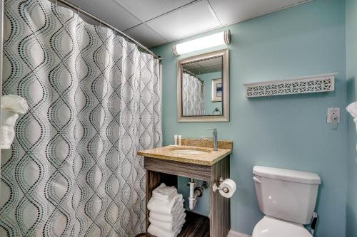 ein Badezimmer mit einem Waschbecken, einem WC und einem Spiegel in der Unterkunft Caravelle Resort 219 in Myrtle Beach