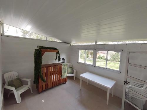 ein Zimmer mit einem Kinderbett und einer Bank und Fenstern in der Unterkunft La Casa de Belén in Villa General Belgrano