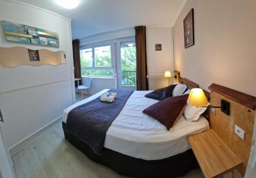 Un dormitorio con una cama grande y una ventana en Hôtel OpalOriental, en Boulogne-sur-Mer