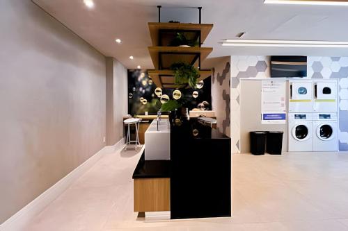 a laundry room with a black counter and white appliances at Zainalofts7 Pinheiros - Z Pinheiros 107 in Sao Paulo