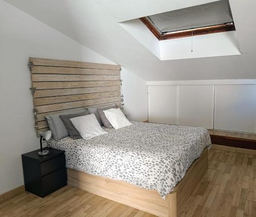 a bedroom with a bed with a wooden headboard at Precioso Dúplex con terraza a 5 minutos playa y 20 minutos de Barcelona in Premiá de Mar